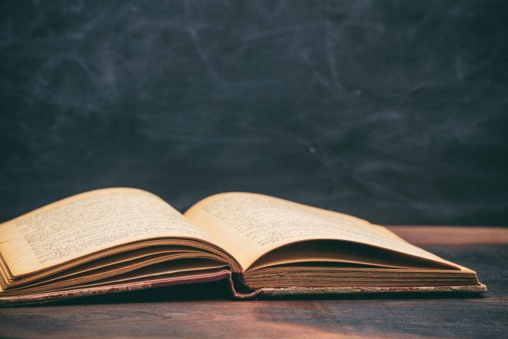 Vintage book on blackboard background