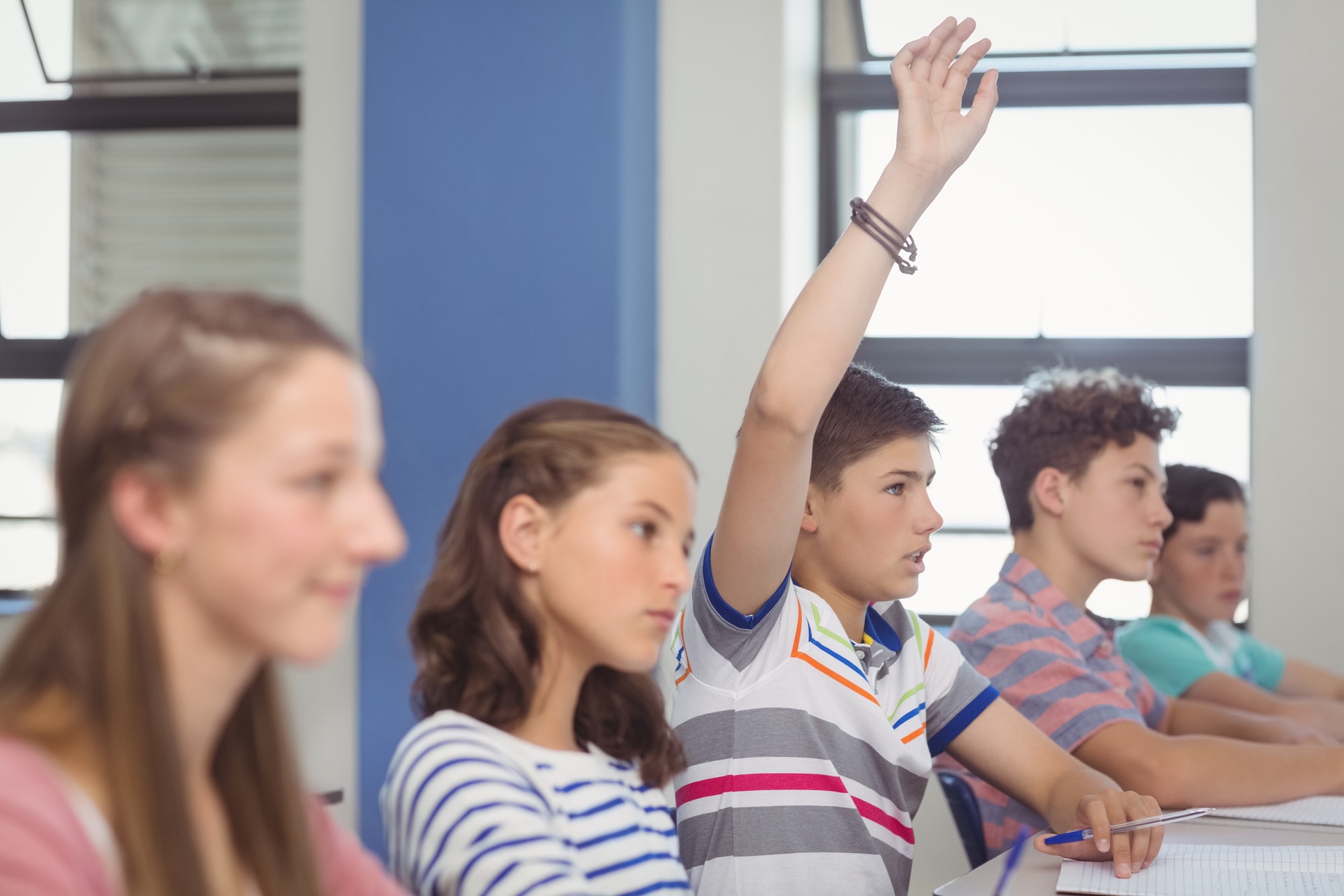 Student raising hand in classroom