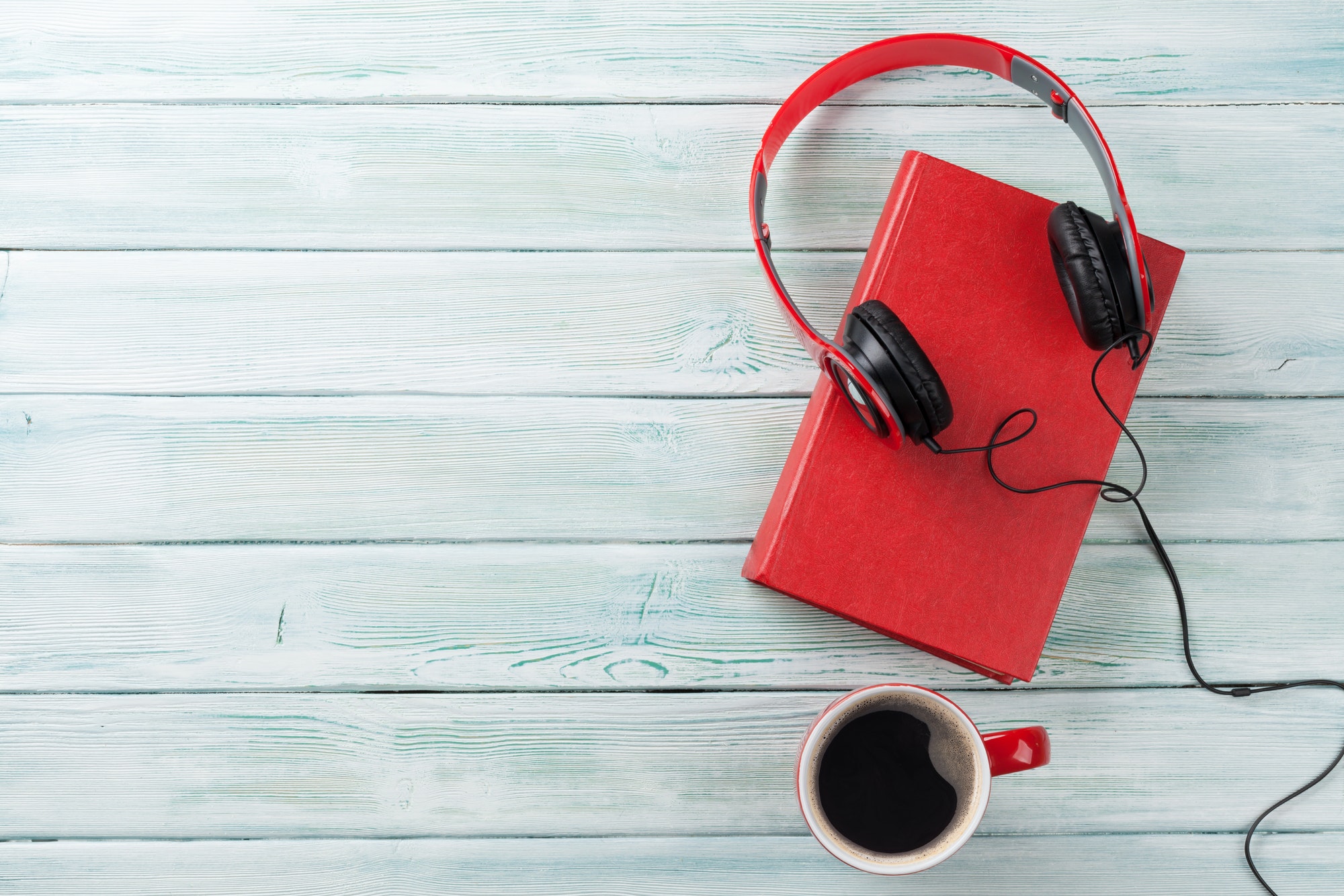 Audio book concept. Headphones, coffee and book